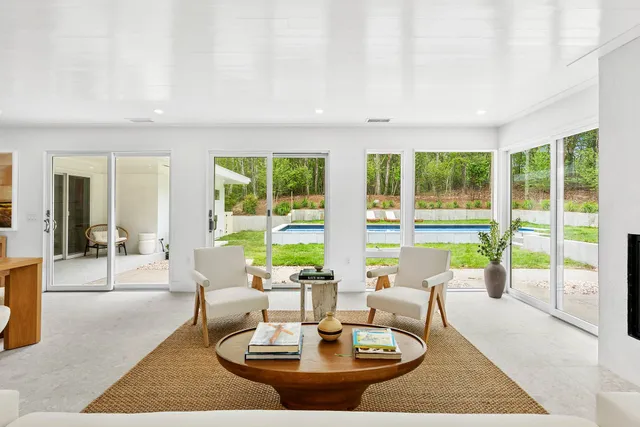 a living room with large couches with a dining table and a couches with wooden floor