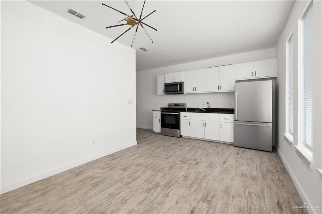 1429 West Harrison Avenue, Unit 3 Alton, TX 78573 - Photo 3 of 9 a kitchen with stainless steel appliances a refrigerator and a stove top oven