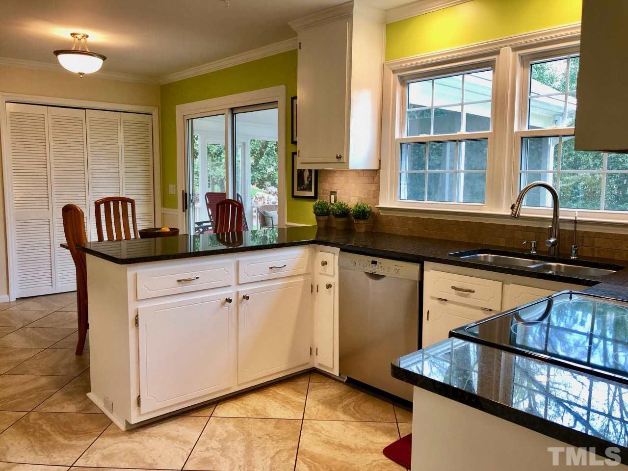 5412 Fairoaks Road Durham, NC 27712 - Photo 12 of 25 a kitchen with stainless steel appliances granite countertop a stove a sink and a granite counter tops with wooden floors