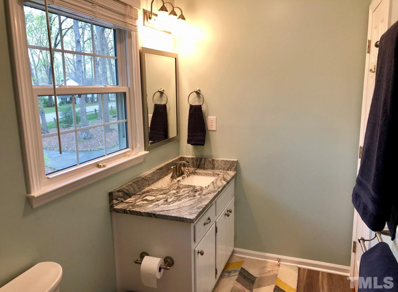 5412 Fairoaks Road Durham, NC 27712 - Photo 23 of 25 a bathroom with a granite countertop sink and a mirror