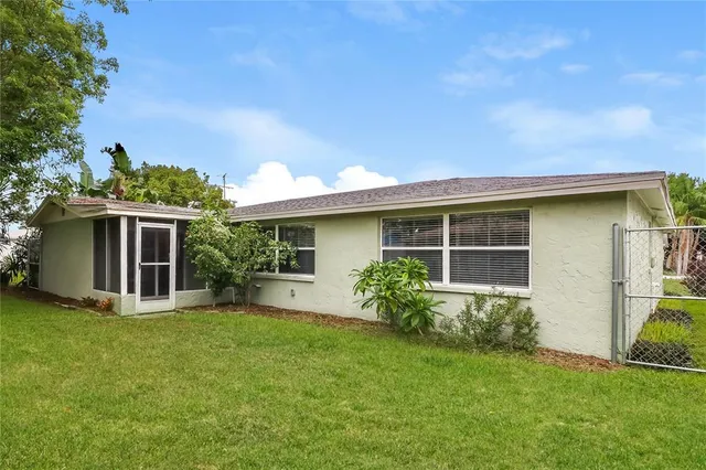 a view of a yard in front of a house with a large tree