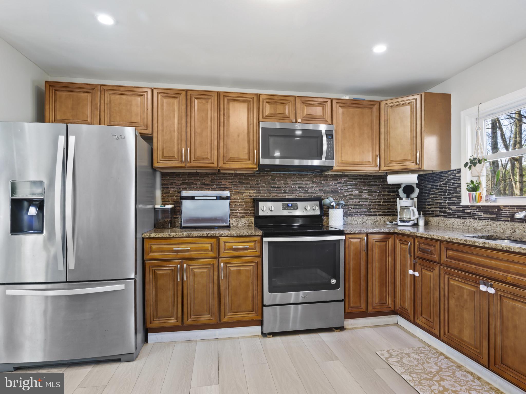 1371 Dicus Mill Road Severn, MD 21144 - Photo 11 of 35 a kitchen with stainless steel appliances granite countertop a refrigerator stove microwave and sink