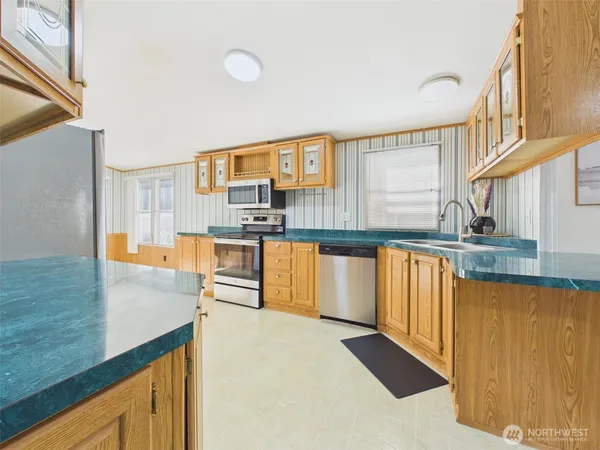 a kitchen with stainless steel appliances granite countertop a stove a sink and a refrigerator