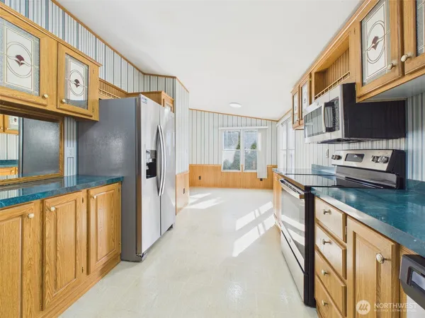 a kitchen with stainless steel appliances granite countertop a refrigerator a stove and a sink with cabinets