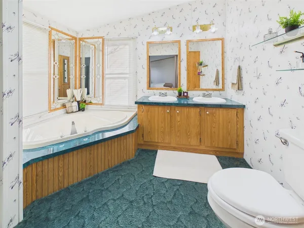 a bathroom with a sink a toilet and mirror