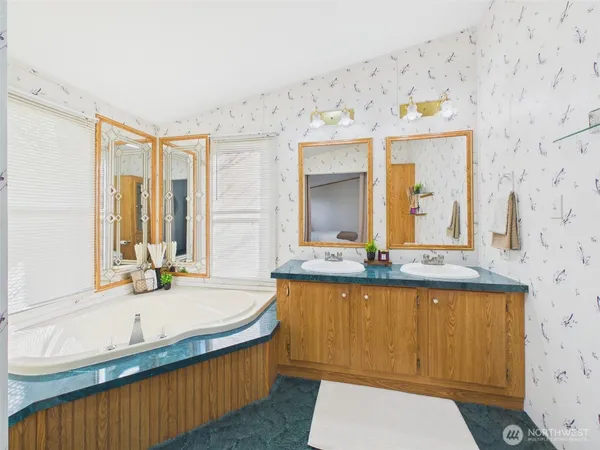 a bathroom with a granite countertop sink and a large mirror