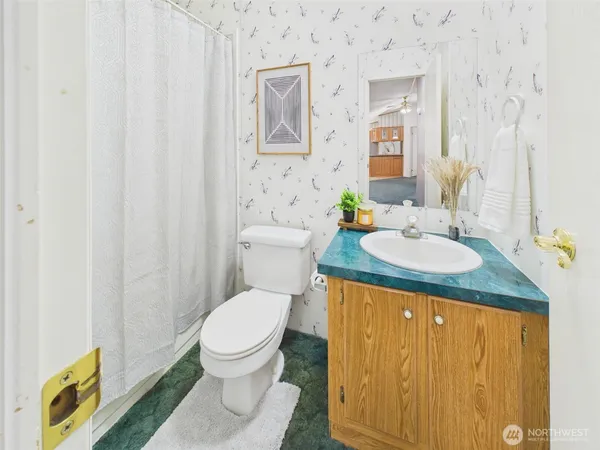 a bathroom with a granite countertop sink toilet and a mirror