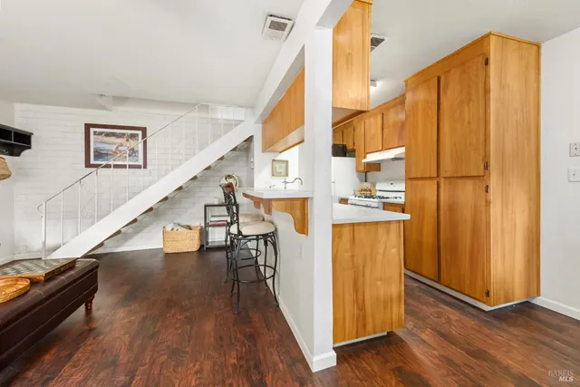 a view of a living room with wooden floor and stairs