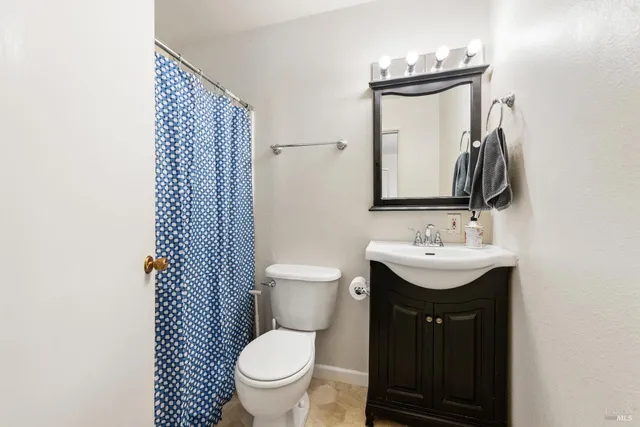 a bathroom with a toilet sink and mirror