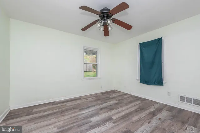 an empty room with a window and a ceiling fan