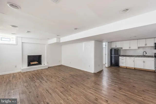 a view of empty room with wooden floor and fireplace