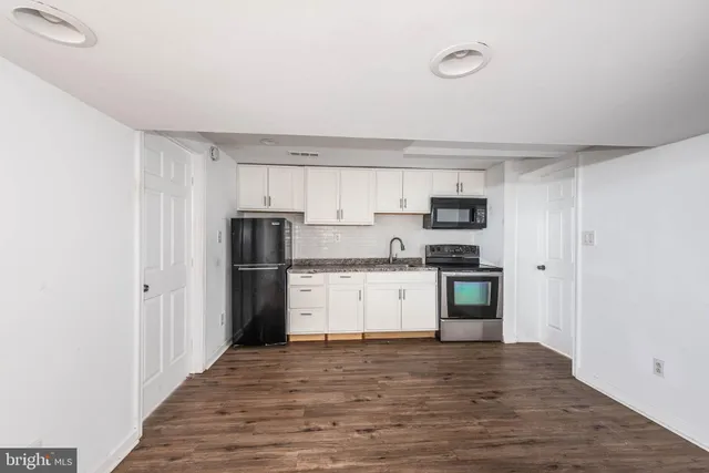 a kitchen with a refrigerator stove and wooden cabinets