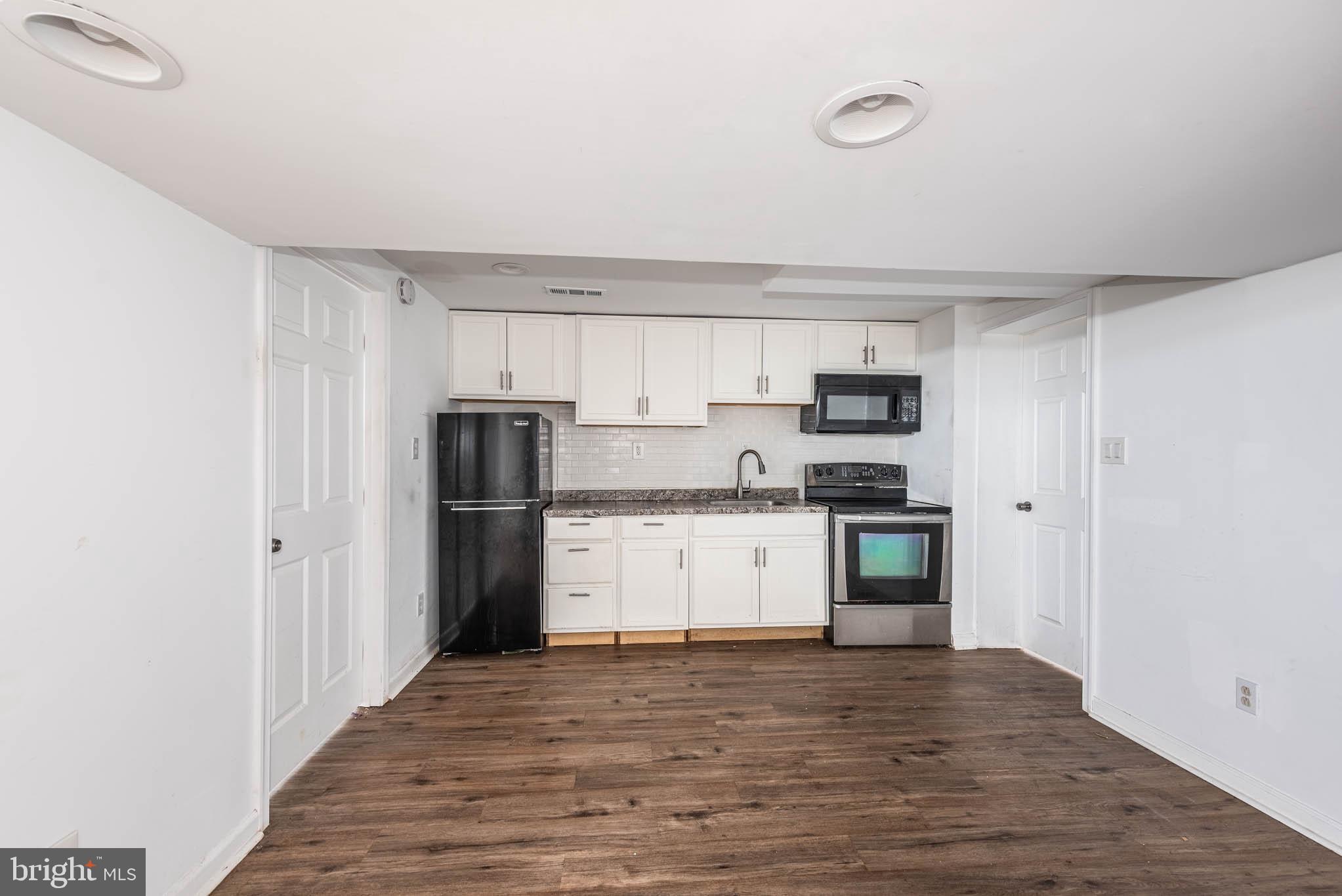 6702 Queens Ferry Road Baltimore, MD 21239 - Photo 28 of 40 a kitchen with a refrigerator stove and wooden cabinets