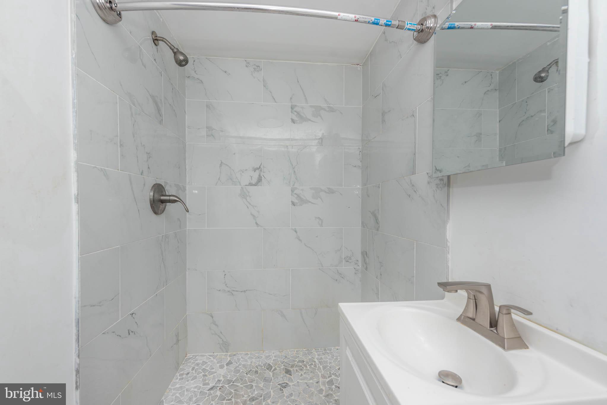 6702 Queens Ferry Road Baltimore, MD 21239 - Photo 32 of 40 a bathroom with a sink and shower