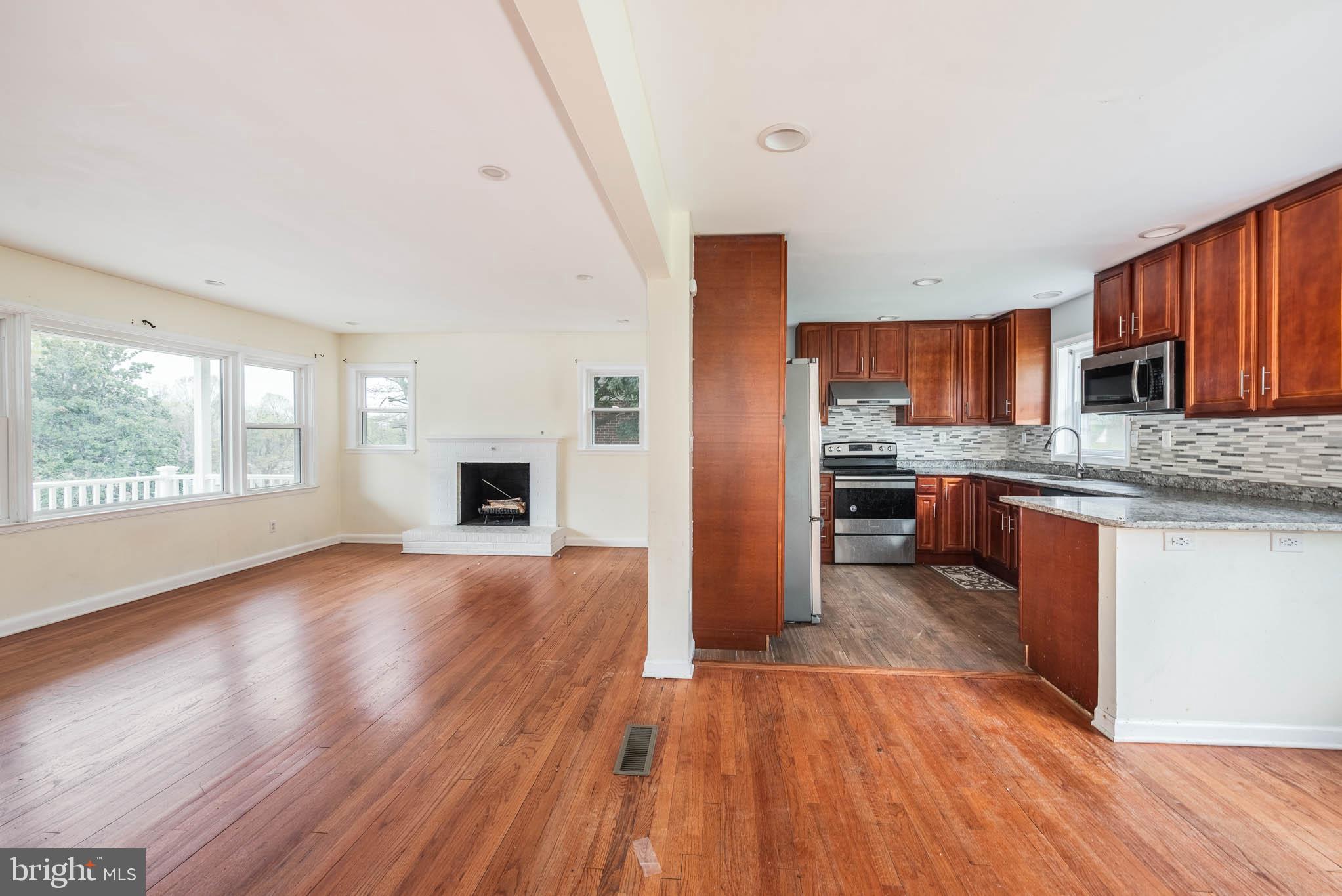 6702 Queens Ferry Road Baltimore, MD 21239 - Photo 10 of 40 a kitchen with stainless steel appliances granite countertop a stove top oven a sink dishwasher and a microwave oven on the wooden floor
