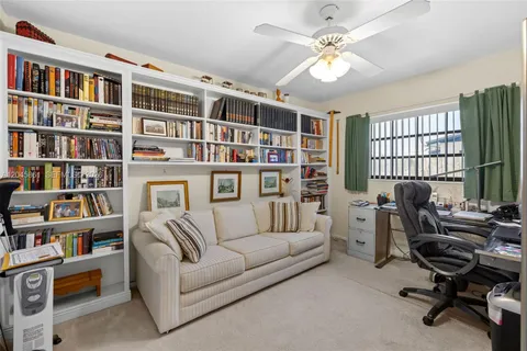 a view of a livingroom with workspace and a bookshelf