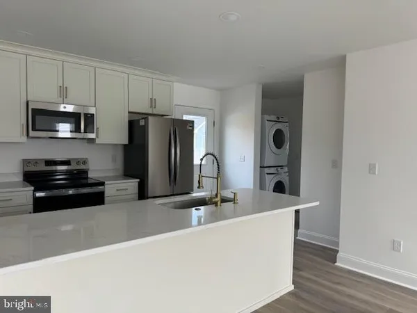 a kitchen with stainless steel appliances granite countertop a refrigerator a stove a sink and a microwave