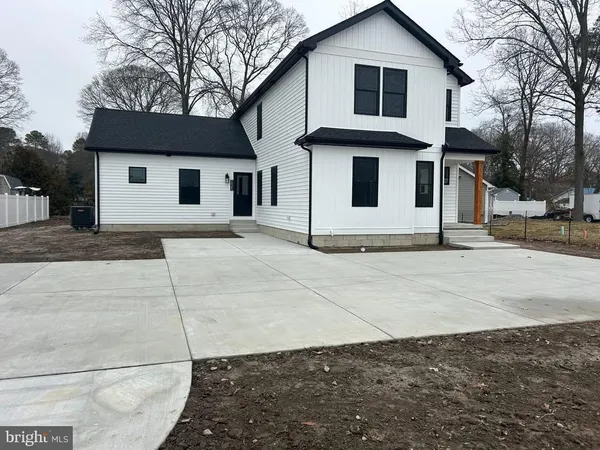 a white house that has a tree on the side of it