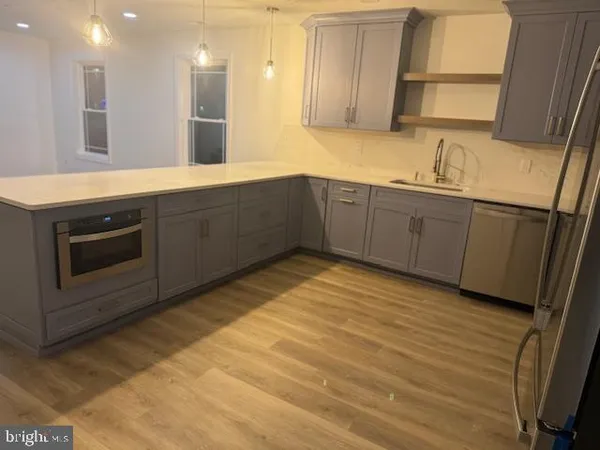 a kitchen with stainless steel appliances granite countertop a sink a stove and a refrigerator