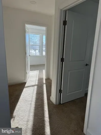 a view of a hallway with wooden floor and a livingroom