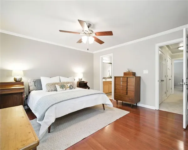 a spacious bedroom with a bed and wooden floor