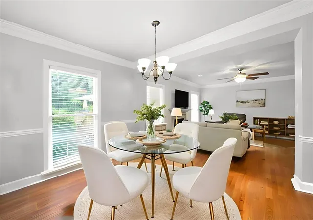 a dining room with furniture wooden floor a chandelier and a rug