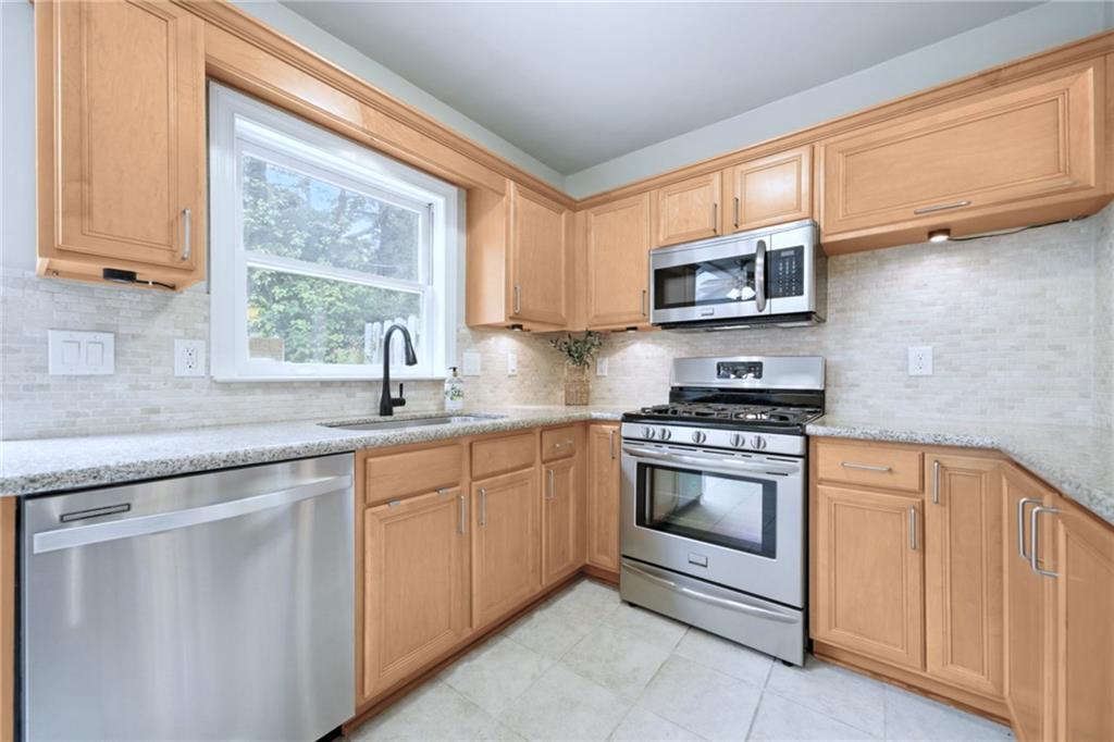 44 Mt Vernon Circle Sandy Springs, GA 30338 - Photo 10 of 27 a kitchen with stainless steel appliances granite countertop a sink a stove and cabinets