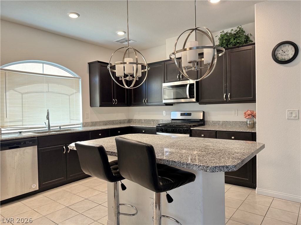 7777 South Westwind Road Las Vegas, NV 89139 - Photo 26 of 46 An inviting kitchen with rich cabinetry and polished granite counters.