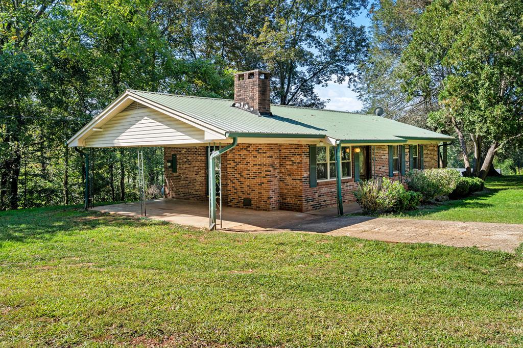 a view of a house with a yard and sitting area
