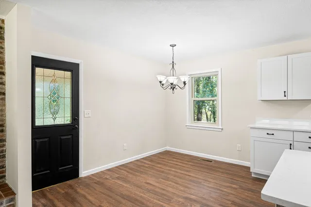 a view of a kitchen with a sink window and wooden floor