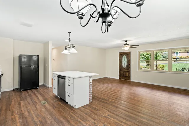 a view of a kitchen with stainless steel appliances granite countertop a stove oven a refrigerator with wooden floor
