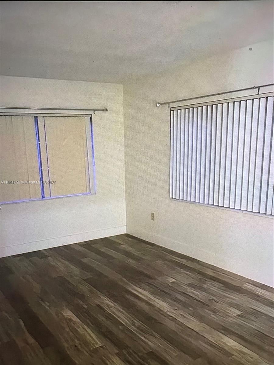 13864 Southwest 90th Avenue, Unit 108LL Miami, FL 33176 - Photo 5 of 10 a view of an empty room with wooden floor and a window