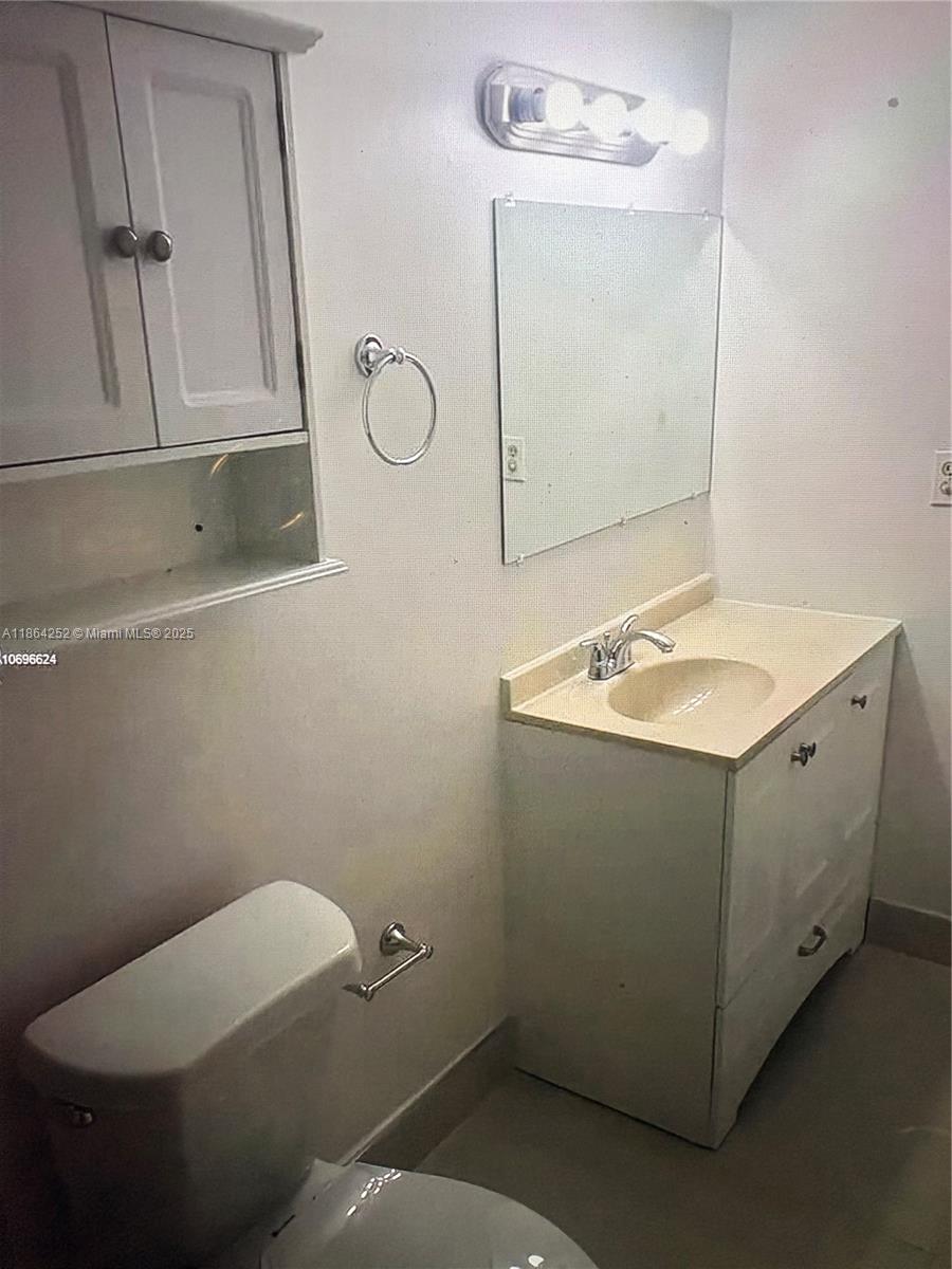 13864 Southwest 90th Avenue, Unit 108LL Miami, FL 33176 - Photo 6 of 10 a bathroom with a toilet sink and mirror