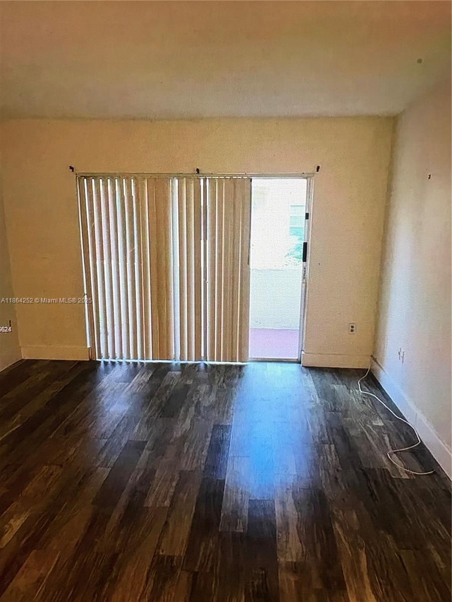 13864 Southwest 90th Avenue, Unit 108LL Miami, FL 33176 - Photo 7 of 10 an empty room with wooden floor and windows