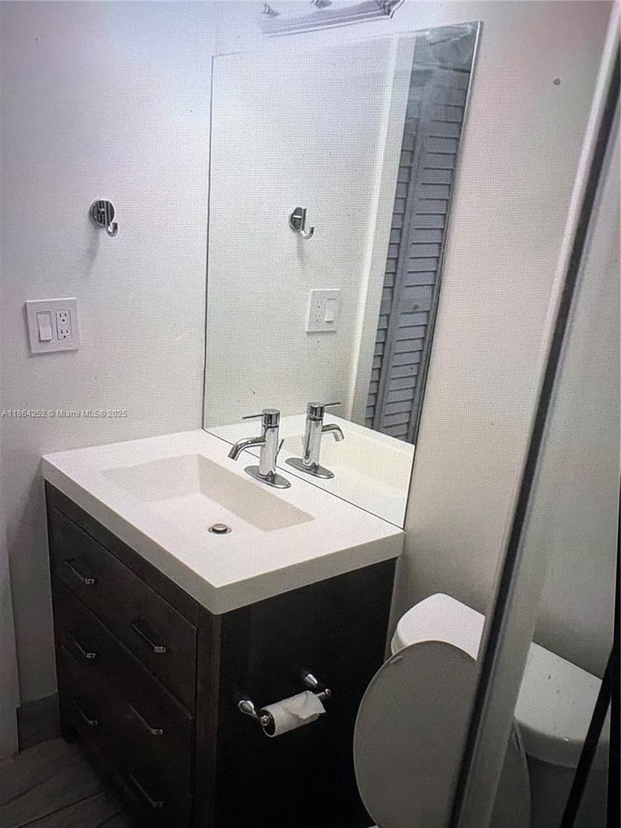 13864 Southwest 90th Avenue, Unit 108LL Miami, FL 33176 - Photo 8 of 10 a bathroom with a sink vanity and toilet
