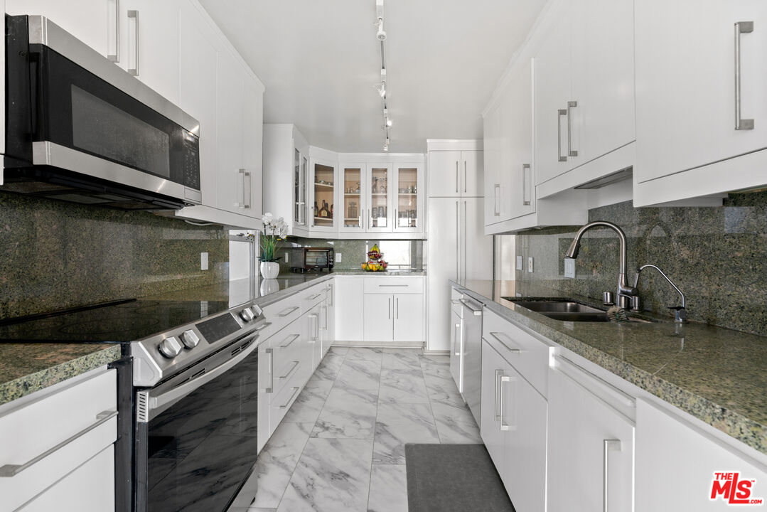 201 Ocean Avenue, Unit 1204B Santa Monica, CA 90402 - Photo 7 of 26 a kitchen with stainless steel appliances granite countertop a stove a sink and a microwave