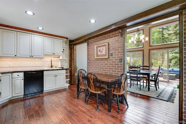 a open dining room with stainless steel appliances granite countertop furniture wooden floor and a window