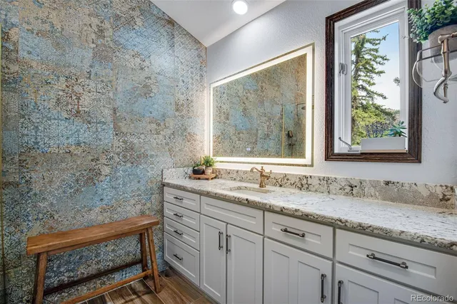 a bathroom with a granite countertop sink a mirror and a window