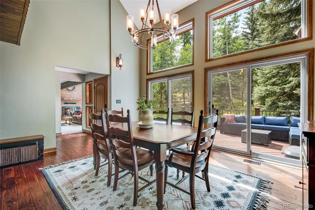 a dining room with furniture a chandelier and wooden floor