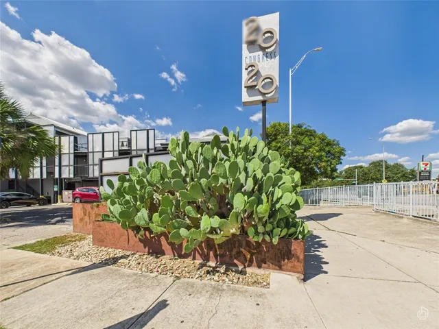 a view of a street with potted plants