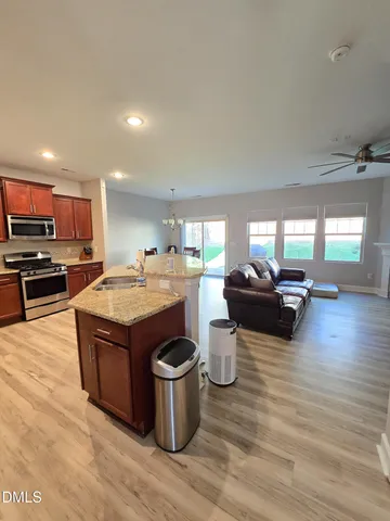 a living room with furniture a flat screen tv and kitchen view