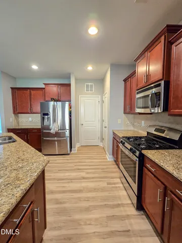 a kitchen with stainless steel appliances granite countertop a stove a sink and a microwave
