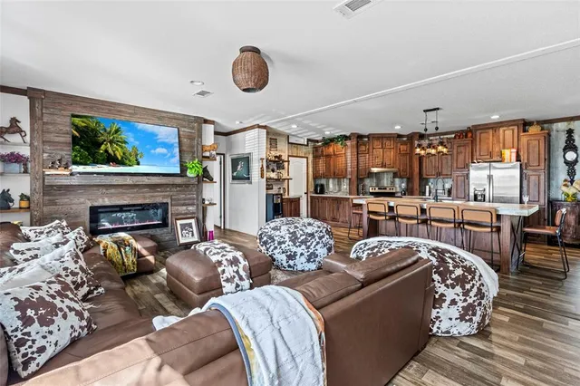 a bedroom with a large bed dresser and wooden floor