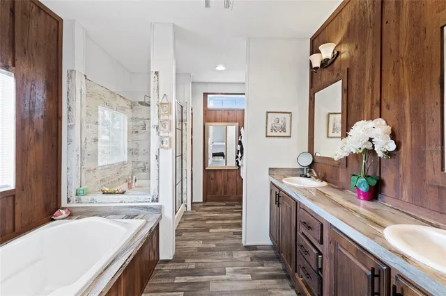 a kitchen with stainless steel appliances granite countertop a refrigerator a oven a sink dishwasher and a stove with wooden floor