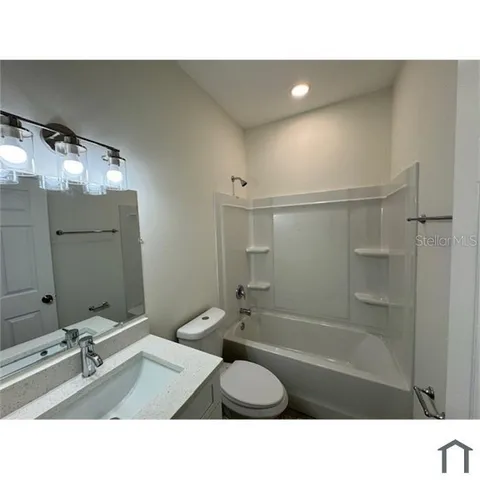 a bathroom with a sink tub shower and a mirror
