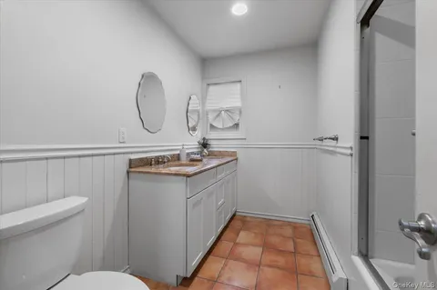 a bathroom with a sink a toilet and a mirror