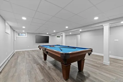 a room with wooden floor and pool table