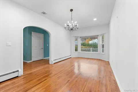 a view of a room with wooden floor chandelier and a window