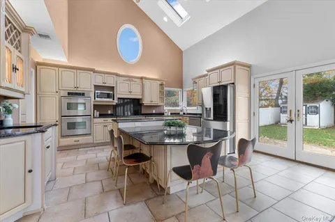 a kitchen with stainless steel appliances a dining table chairs and refrigerator