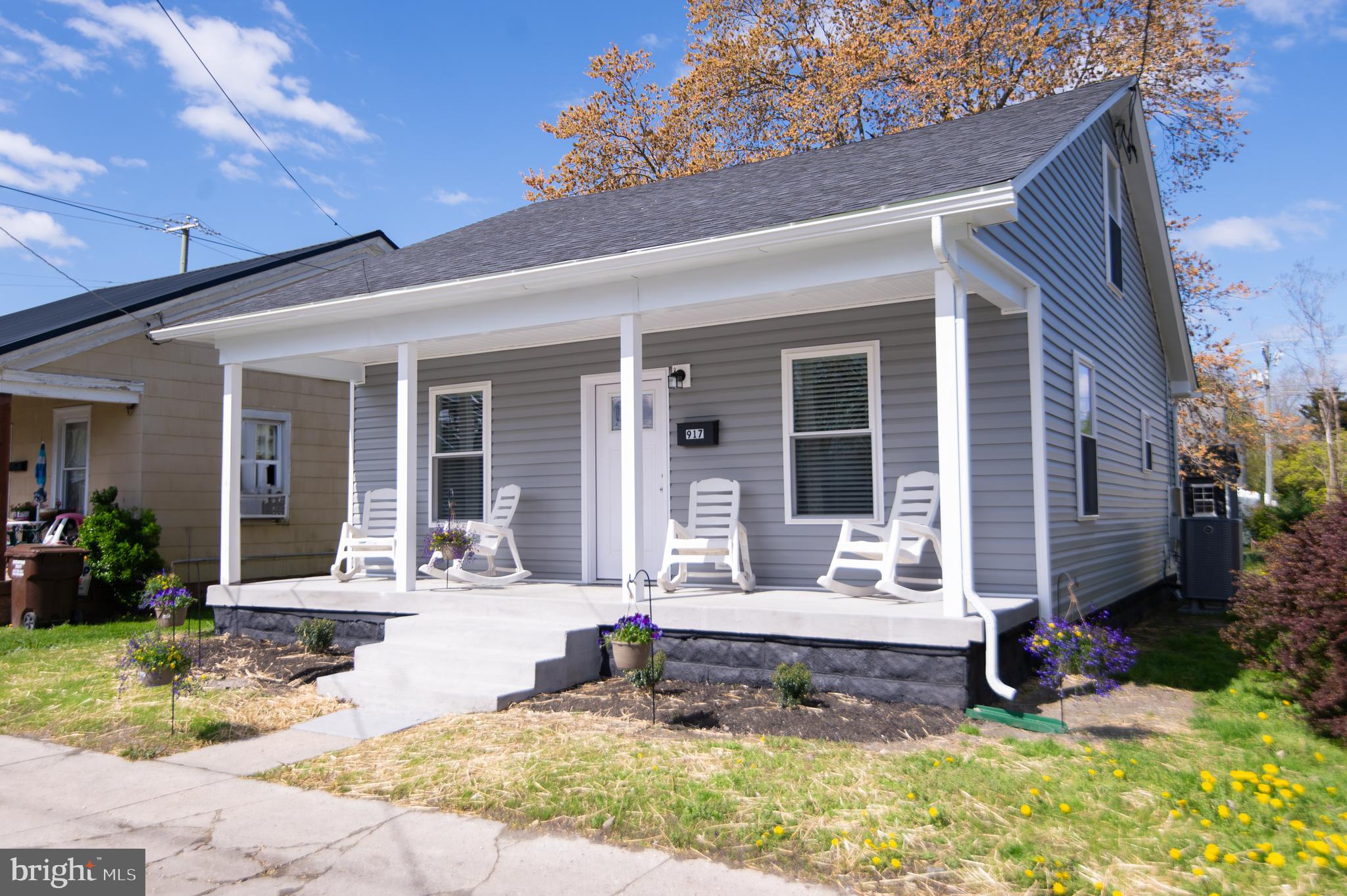 a front view of a house with swimming pool and porch with furniture